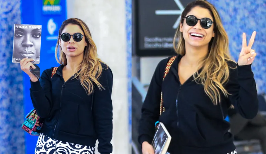 Ao desembarcar em aeroporto, cantora Lexa exibe a biografia de Viola Davis