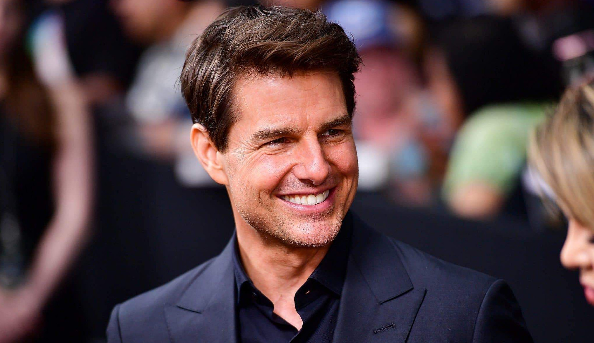 Tom Cruise pousa helicóptero em quintal de fãs e posa para fotos com a família