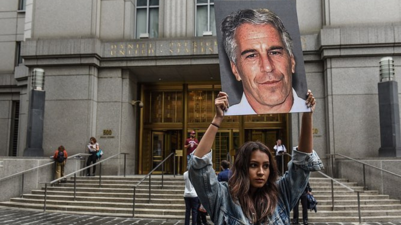 Mulher segura cartaz com foto de Jeffrey Epstein | Reprodução/Instagram/@steffikeith