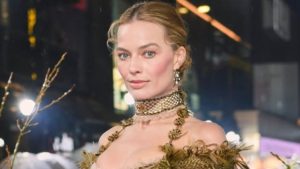 Margot Robbie surge com look transparente e dramático em première