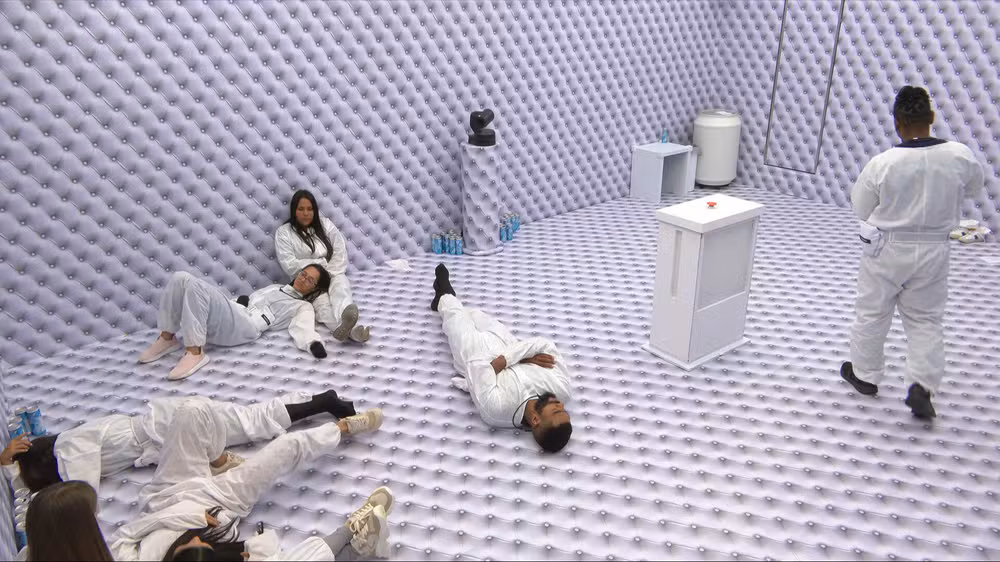 Participantes do Big Brother Brasil 26 (BBB) em um quarto branco, usando roupas também brancas.